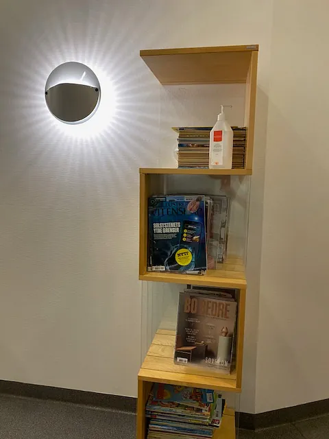 Hyller med magasiner og håndsprit på venterom