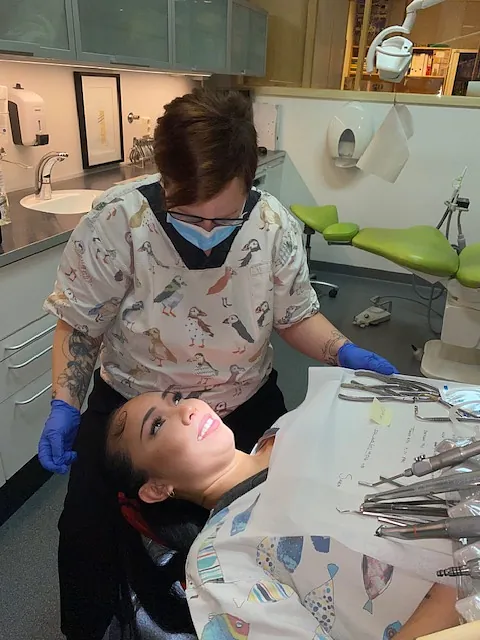 Tannlege og pasient i samtale under behandling i moderne tannklinikk.