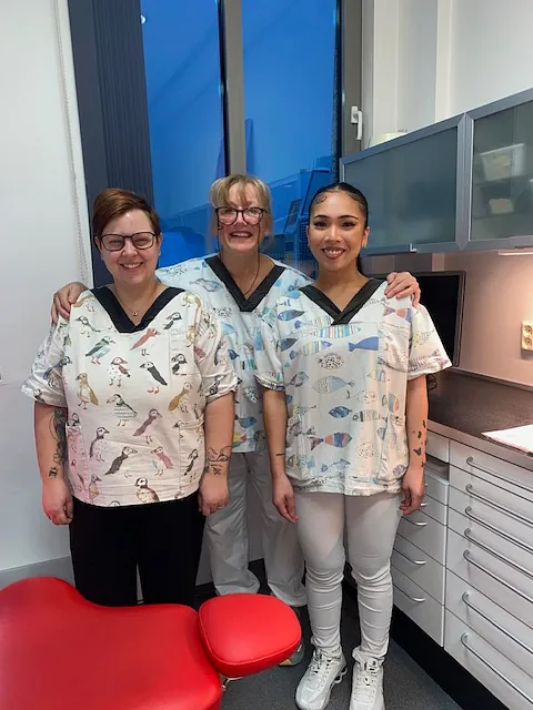 Tre tannleger står sammen på tannlegekontor