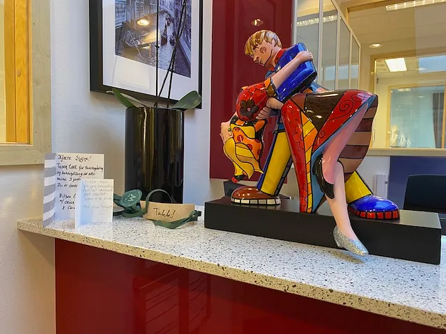 Kunstverk og handskrevne beskjeder ligger på resepsjonsdisk